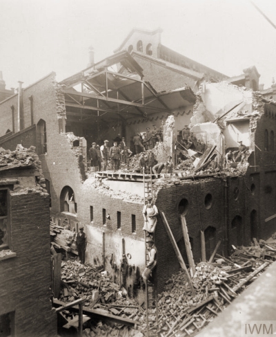 “A general view of the damage caused to buildings on Pancras Road, King's Cross, during the second daylight raid on London by German Gotha GV aircraft on 7 July 1917. A team of soldiers and civilians can be seen on an upper floor of the building, which is open to the elements, the roof having been destroyed in the blast, helping to clear the rubble.” © IWM (HO 76)